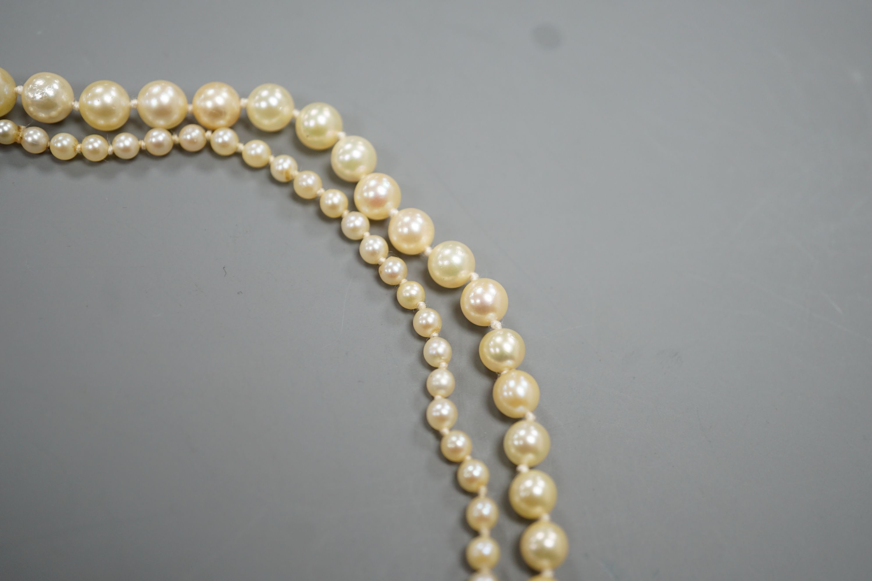 A singe strand graduated cultured pearl necklace with yellow metal clasp, 64cm, gross weight 20.3 grams.